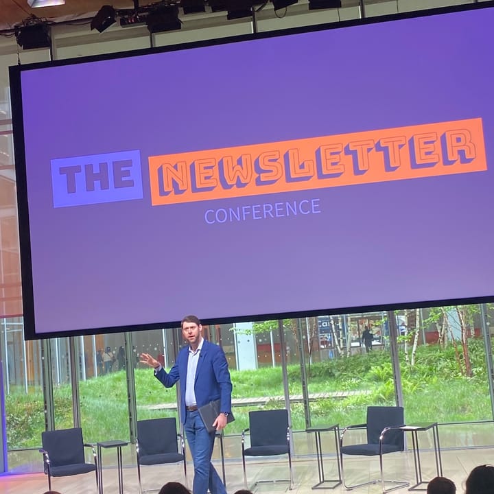 Dan Oshinksy stands in front of a banner that says The Newsletter Conference.